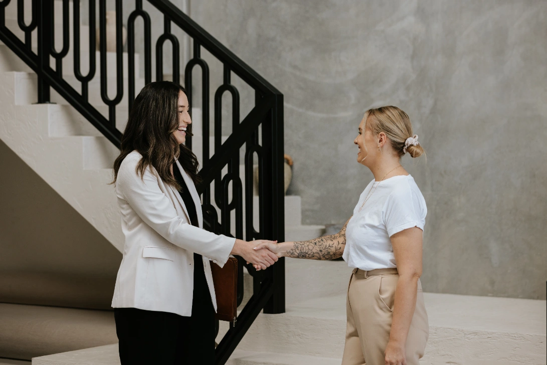 what-is-litigation Smiling professional female lawyer shaking hands with blond haired woman