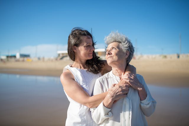 White middle-aged female smiling at white elderly woman