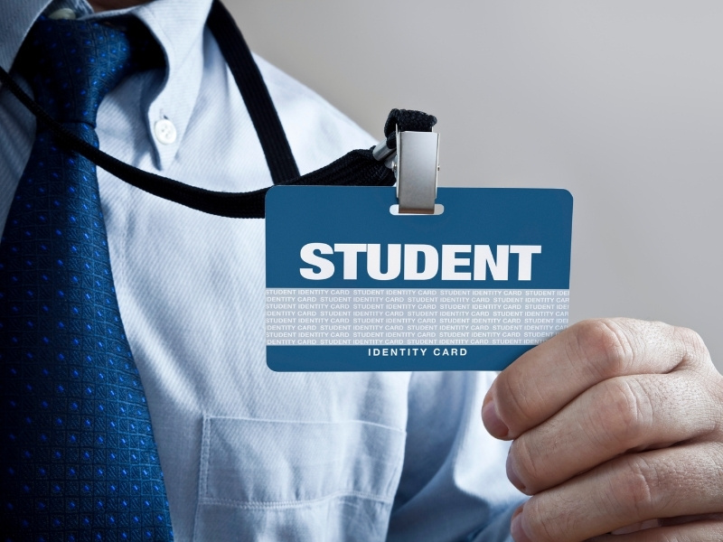 Someone presenting a student id around their neck