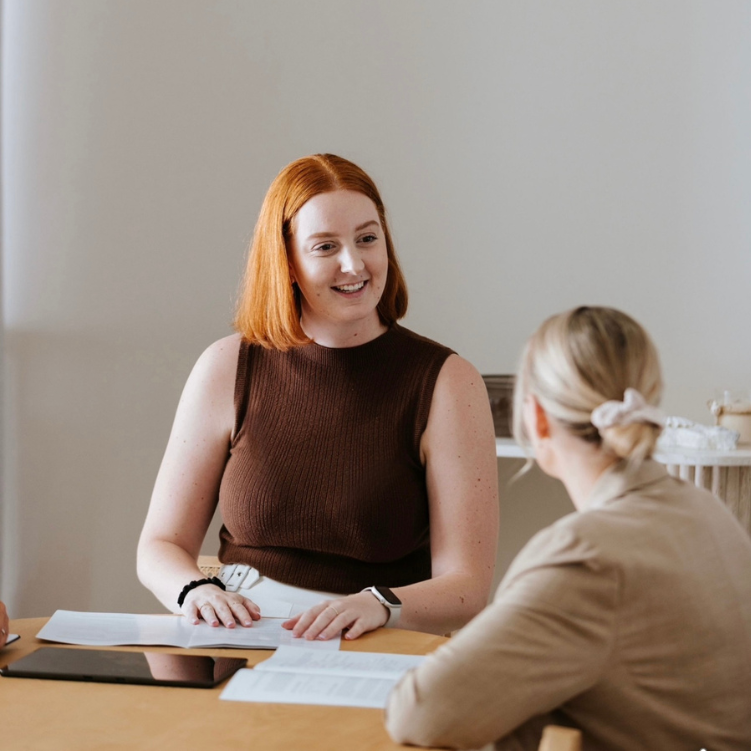 Female red-haired estate  litigation solicitor smiling at blond female client